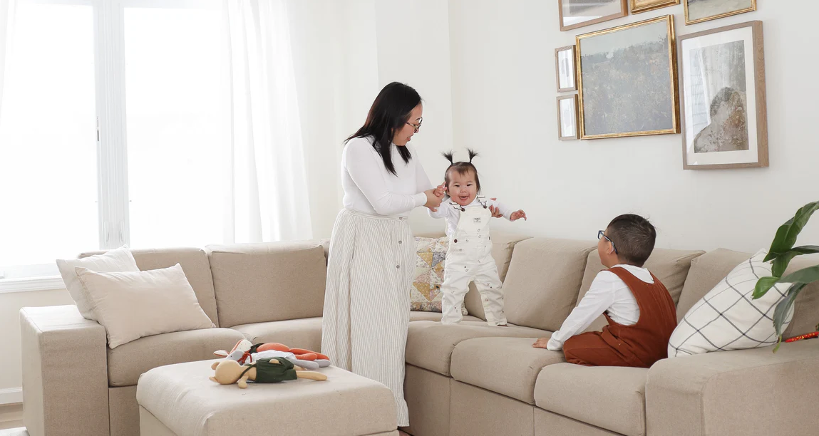 Mother playing with children on the couch.